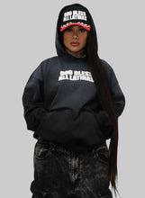 Load image into Gallery viewer, Person wearing a black hoodie with text and matching pants against a white wall.